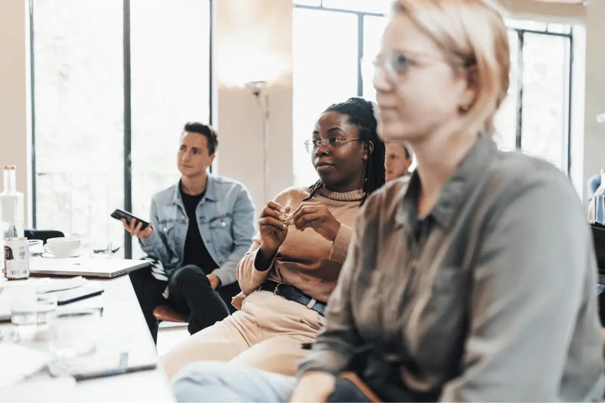 Group of professionals attentively listening during a modern office workshop.