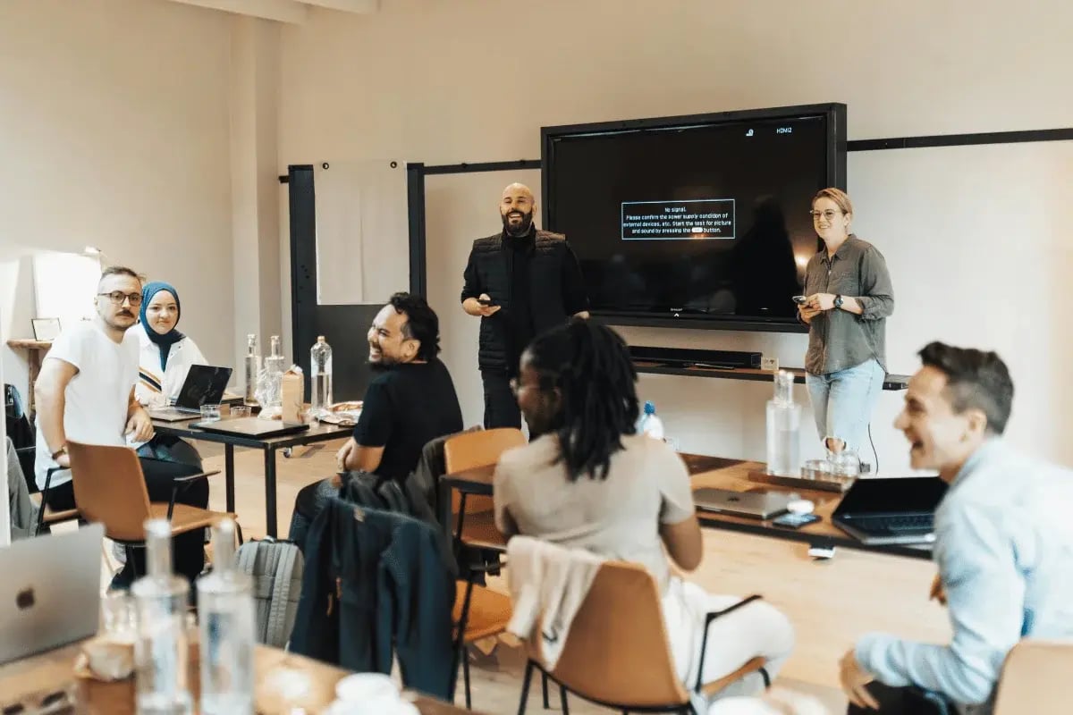 Team members attending a business workshop with a presentation on a large screen.