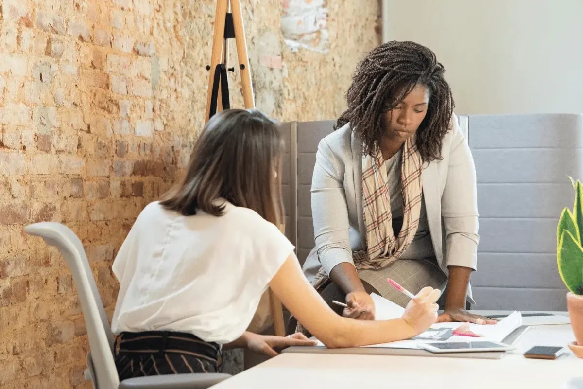 Business partners working together on documents at office desk.