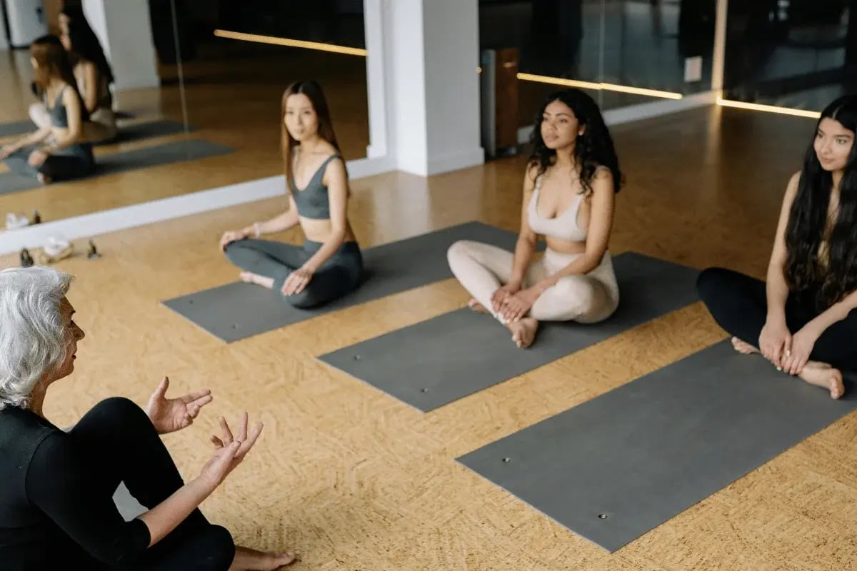 Yoga instructor leading a seated class in a modern studio.