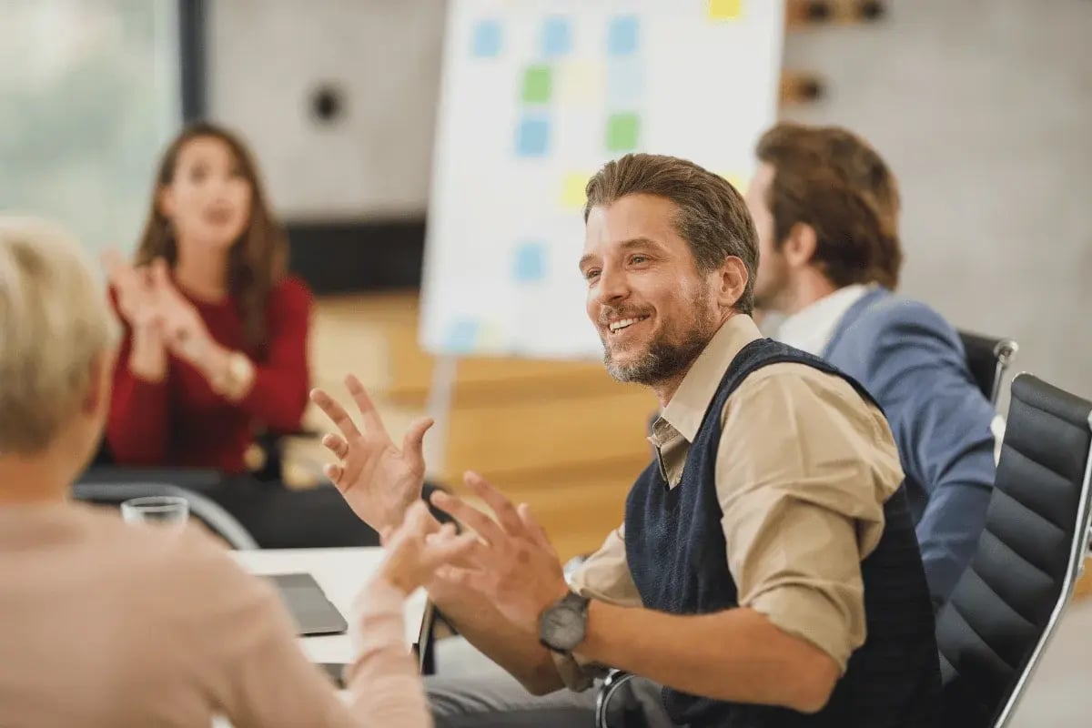 Smiling businessman leading office team discussion.