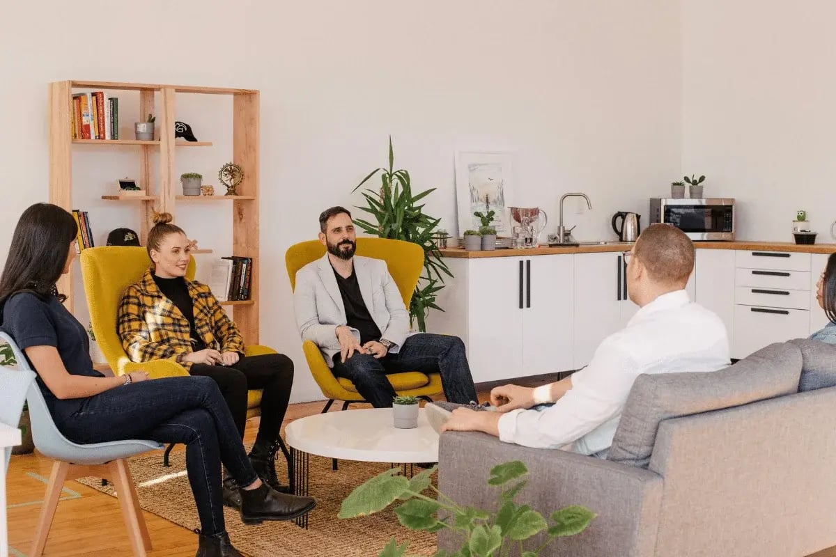 Group of professionals having a casual team meeting in lounge.