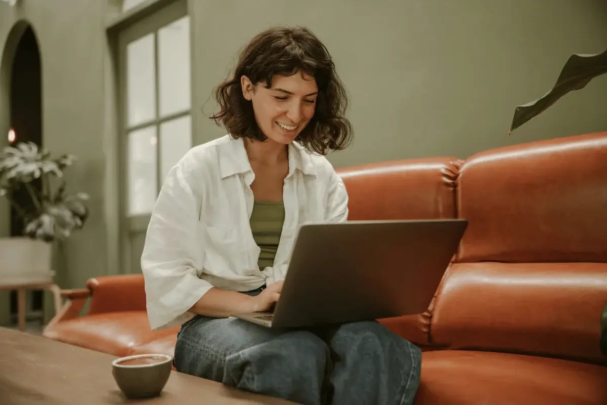 Casual remote work setup with a woman on a laptop.