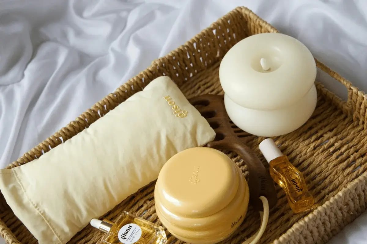 Natural self-care gift basket with oils, candles, and sleep pillow.