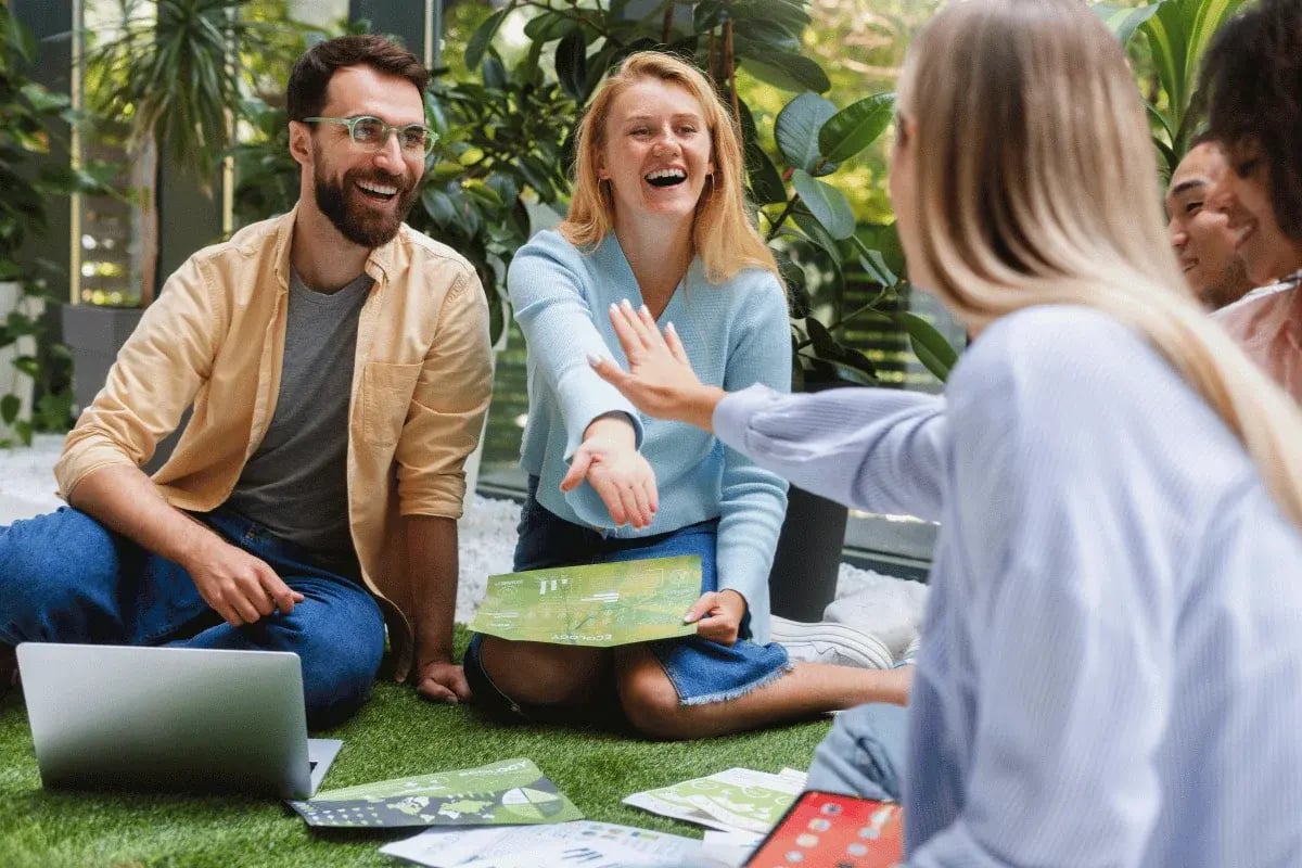 Team meeting in a modern, nature-inspired workspace with charts and laptops.