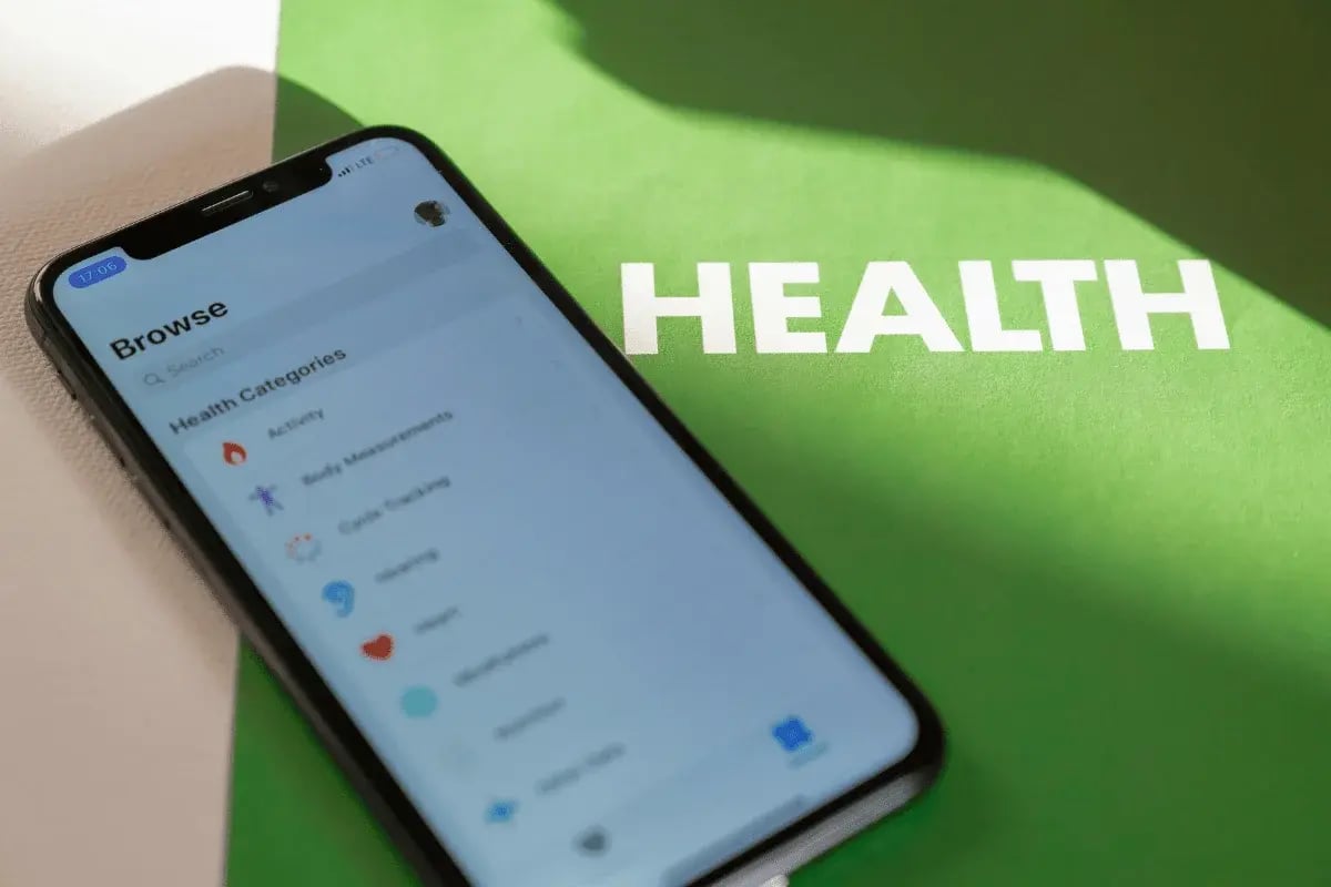 Smartphone displaying a health tracking app on a green background labeled “HEALTH.”