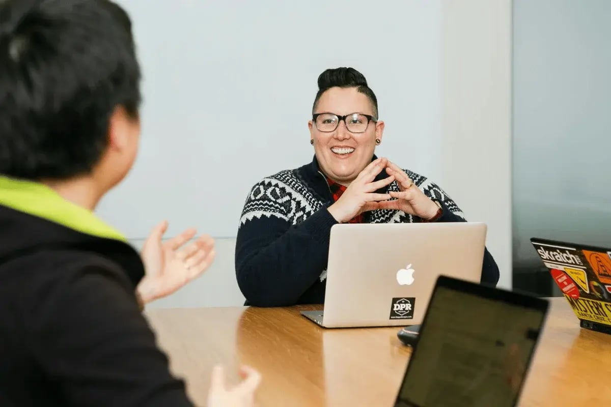 Smiling business professional leading meeting with laptop.