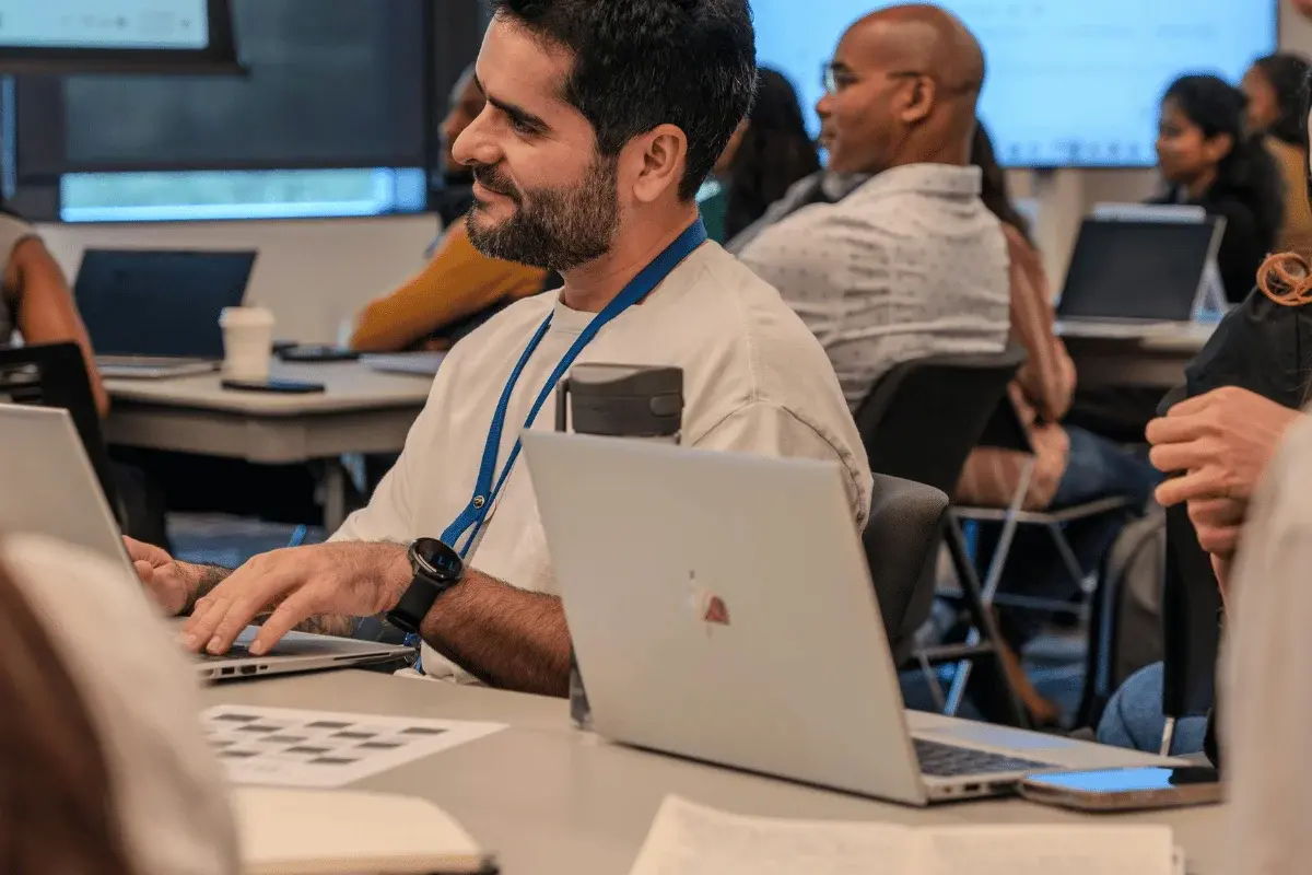 Smiling man with laptop attending professional workshop.