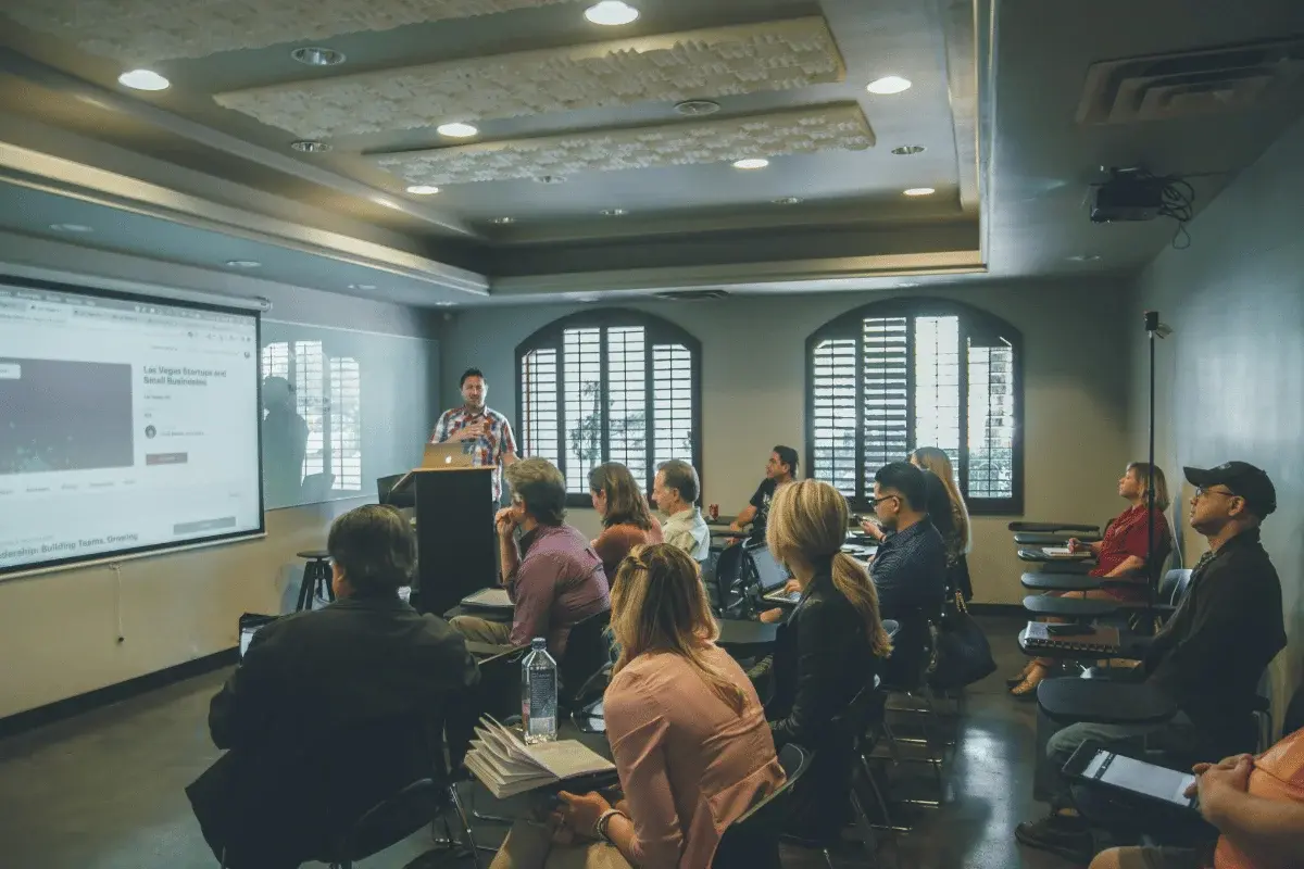 A business presentation in progress, with an audience listening intently while the speaker explains a concept.